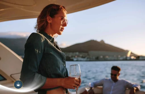 mujer a bordo de un yate con una copa en la mano y otras personas de fondo Fiestas privadas en yate en Cartagena: organiza tu evento en el agua navega colombia
