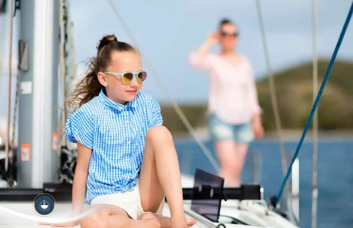 niña sentada en bote mirando frente a ella mujer difuminada detrás Seguro para alquiler de yates en Colombia: qué cubre y si es obligatorio navega colombia